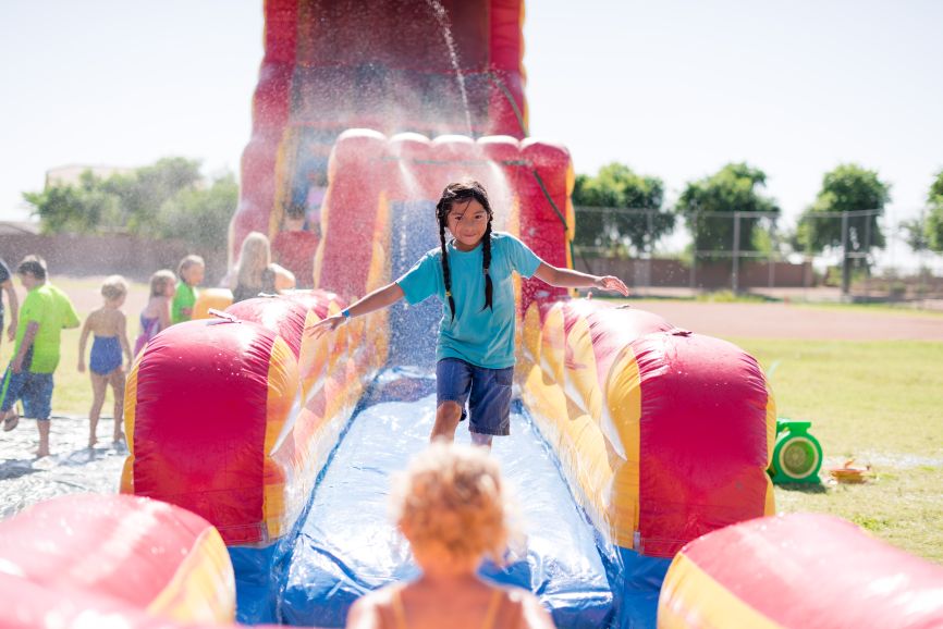 Bouncy Castle Hire Seven Kings with children enjoying a fun inflatable slide by Bizi Bouncers UK at an outdoor party
