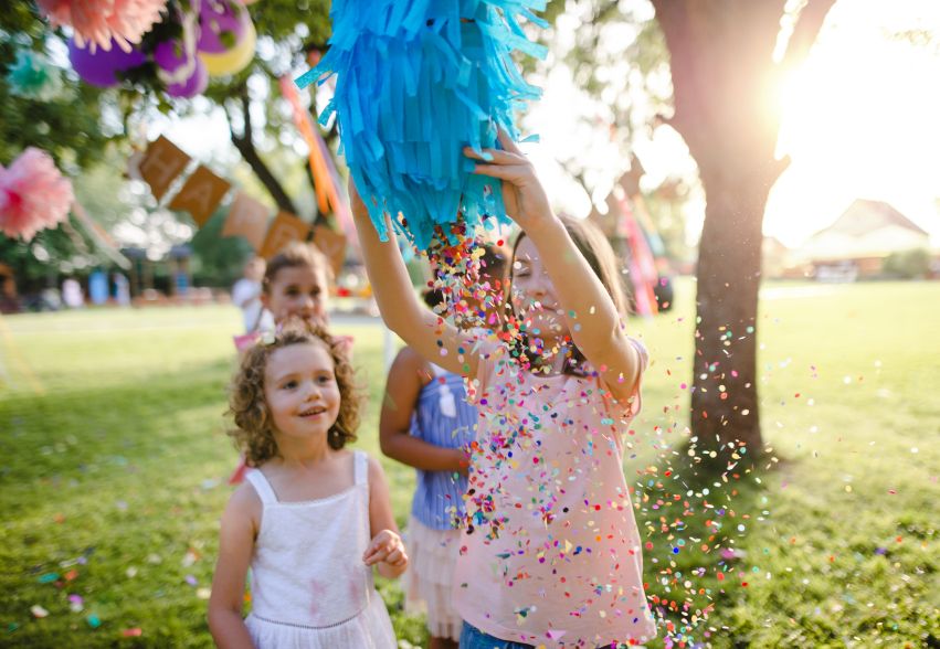 Themed kids garden party setup with decorations and inflatables in summer