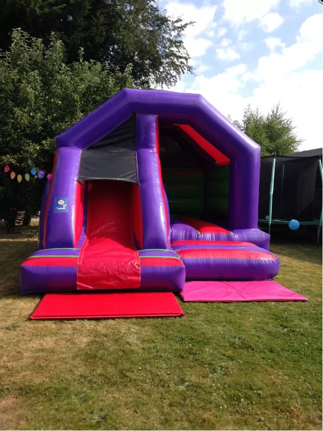 Vibrant bouncy castle with front slide and bold primary colours, ideal for children’s parties