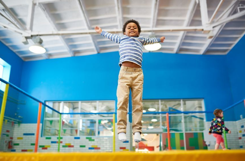 Child jumping happily on an indoor inflatable play area provided by Bizi Bouncers UK for Indoor Bouncy Castle Hire Barkingside