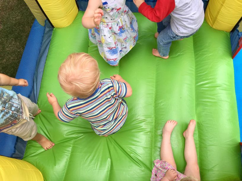 Safety First: Keeping Kids Safe on Bouncy Castles During Dark Evenings – young children playing safely inside a colourful inflatable bounce house by Bizi Bouncers UK